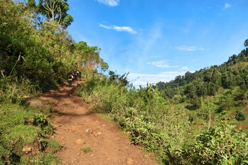 Fototapeta na wymiar A group of hikers in the panoramic rural landscapes in rural Kenya