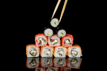 Philadelphia roll with salmon, cheese and cucumber on a black background with reflection. Sushi Philadelphia