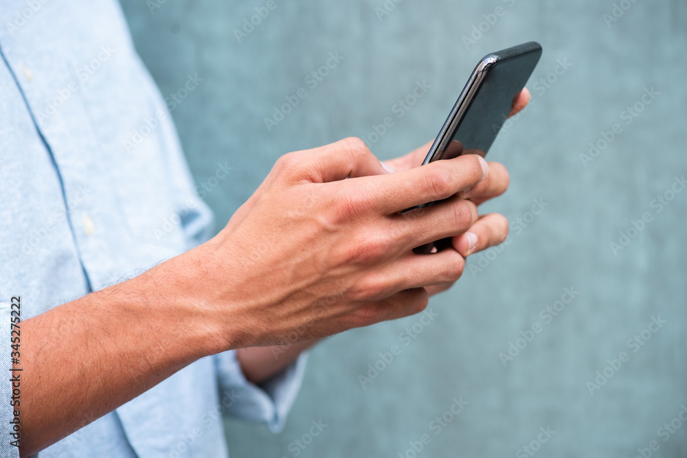 Wall mural close up side caucasian man hands holding mobile phone