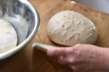 Dough for sourdough bread with nuts and seeds on a wooden table