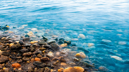 sea ​​shore . small stones piled up along the shore. pebbles lies in the water. clean ponds.
