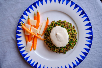 Homemade Quinoa Burger with peas. Served with yoghurt with lemon and turmeric