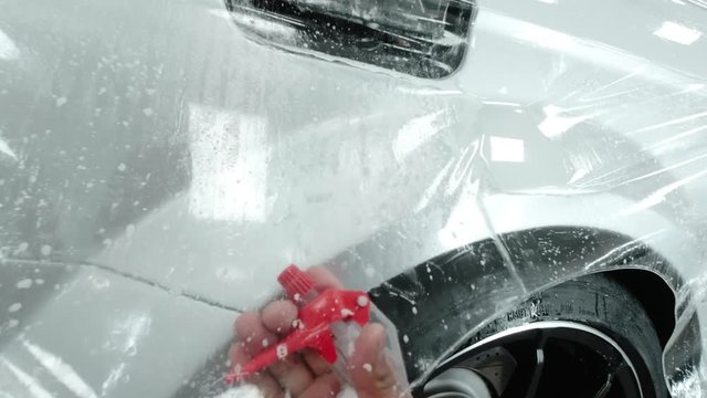 Close up to PPF installation process on silver sports car. PPF is a Paint Protection Film which protect paint from scratches and stone chips.
