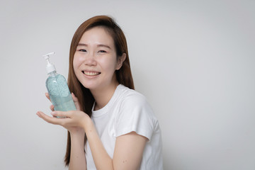 young Asian woman holding portable antibacterial hand sanitizer and present the product antibacterial antiseptic gel for killing germs, bacteria, and viruses.