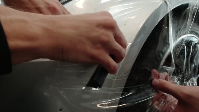 Close up to PPF installation process on silver sports car. PPF is a Paint Protection Film which protect paint from scratches and stone chips.
