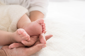 closeup newborn baby feet while the mother is carrying in home. baby feet in mother hands. mom and her Child. happy family concept. beautiful conceptual image of maternity.