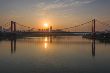 Skyline view of city cable-stayed bridge at sunset