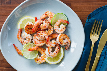 Fried tiger shrimp with lime, lemon and spices on a ceramic dish. Healthy dinner or lunch concept.