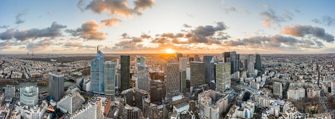 Aerial panoramic drone shot of La Defense skycraper in Paris CBD skyscraper complex business district with clouds during sunset