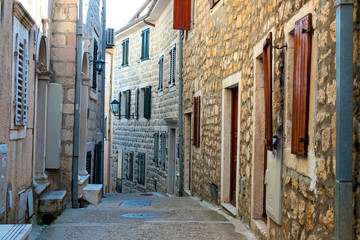 Fototapeta na wymiar Winding street of the authentic, old town of Herceg Novi, Montenegro. We see old houses and very narrow