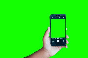 Man holding phone with camera interface against the green screen background