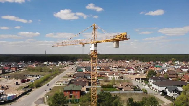 High building construction site. Big industrial tower crane with blue sky amd cityscape on background.