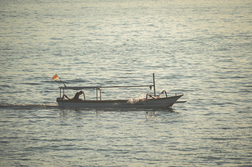 Obraz premium Seascape, fishing boat in the ocean during sunset.
