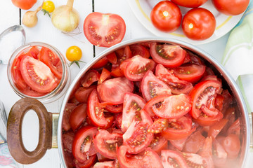 Sliced tomatoes in the pot, tomatoes are prepared for preserves, cooking and food concept, top view