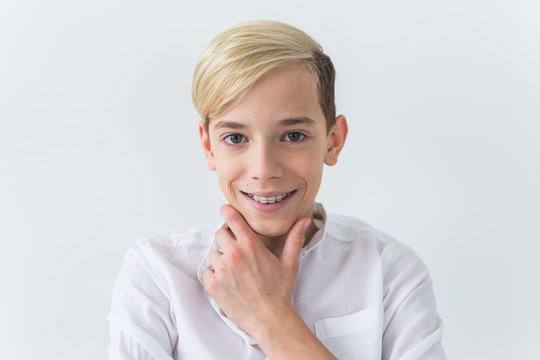 Close-up of teen boy with braces on teeth smiling on white background. Dentistry and teenager concept.