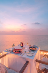 Romantic dinner on the beach with sunset, candles with palm leaves and sunset sky and sea. Amazing...