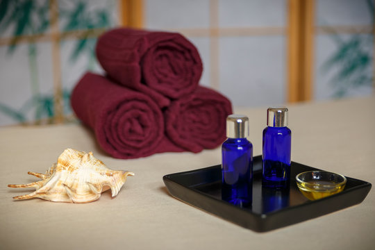 wellness spa decoration with oil bottle, seashell and towels