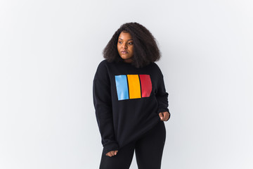 Beautiful African American woman posing in black sweatshirt on a white background. Street fashion photo with afro hairstyle.