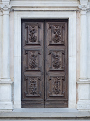 Fototapeta na wymiar Carved wooden portal with scenes of saints from an ancient church.