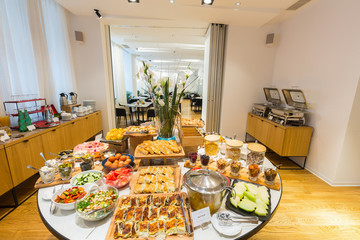 Breakfast served on round buffet table in hotel restaurant