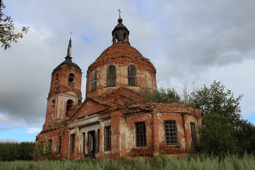 Fototapeta na wymiar abandoned red brick church in the grass