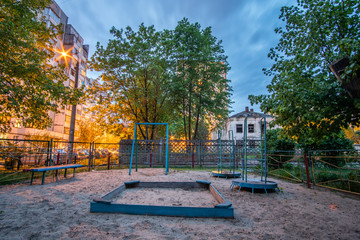 Empty obsolete abandoned children's playground in the evening.