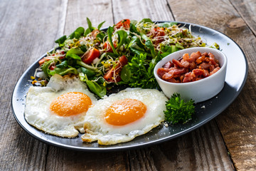 Continental breakfast - sunny side up eggs, bacon and vegetable salad