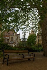 Beautiful dramatic photo of Vajdahunyad Castle in the capital Budapest, Hungary with a lonely empty bench in the foreground