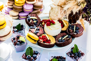 Cute candy bar with macarons and various candies and cakes. Wedding sweets