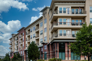 Modern brick and stucco condo buildings with balconies and garages
