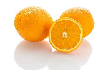 three fresh oranges on a white isolated background with reflection