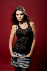 Fototapeta premium Young pretty longhaired woman poses on studio background. Studio shot.