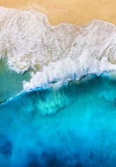 Fototapeta na wymiar Coast with waves as a background from top view. Blue water background from drone. Summer seascape from air. Travel - image