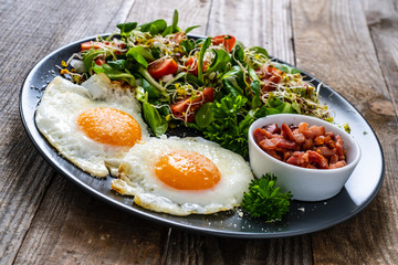 Continental breakfast - sunny side up eggs, bacon and vegetable salad