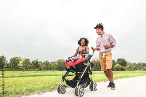 Happy African family having fun together in public park - Afro mother and father with their daughter enjoying time together during weekend outdoor - Parents love and mother's day concept