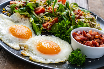 Continental breakfast - sunny side up eggs, bacon and vegetable salad