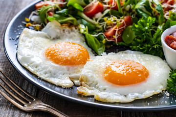 Continental breakfast - sunny side up eggs, bacon and vegetable salad
