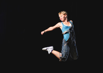 Female modern dancer peforms on stage with lights.