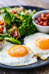Continental breakfast - sunny side up eggs, bacon and vegetable salad