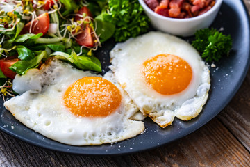 Continental breakfast - sunny side up eggs, bacon and vegetable salad