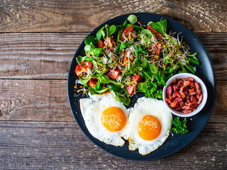 Continental breakfast - sunny side up eggs, bacon and vegetable salad