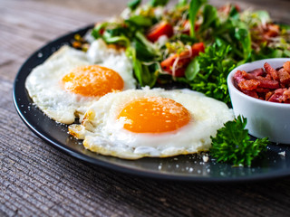 Continental breakfast - sunny side up eggs, bacon and vegetable salad