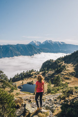 Naklejka premium Kobieta patrzy na górski krajobraz z chmurami