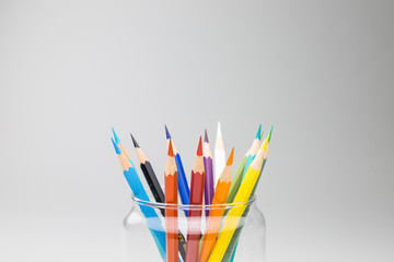 Bright pencils in a glass isolated on white background. A banner concept of work from home WFH with copy space for runaround or wraparound text.