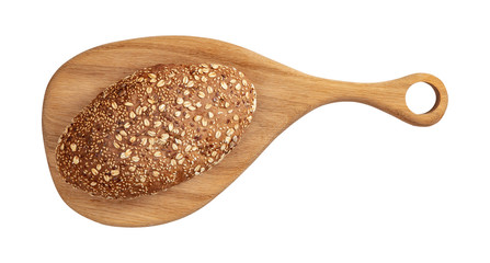 Isolated bread with seeds and flakes on wooden cutting board on white background.