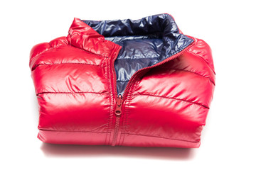 Folded blue and red full zipper windbreaker down jacket, rain proof down jacket. Down jacket sport shiny nylon full zip isolated on white. Folded clothes.