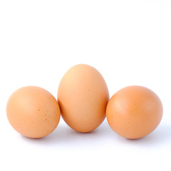 Close-up top view of organic raw eggs on white background with copy space for your text, healthy eating concept.
