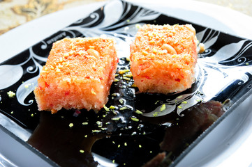Basbousa pie with almonds macro in baking dish on the table. Horizontal.Arabic food.