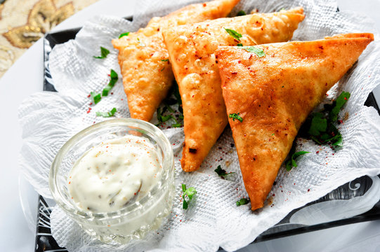 Plate of traditional arabic sambusek with sauce.