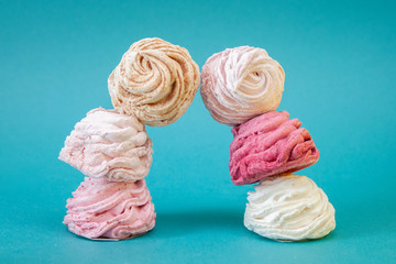 Trendy minimal pink and white meringues on blue background